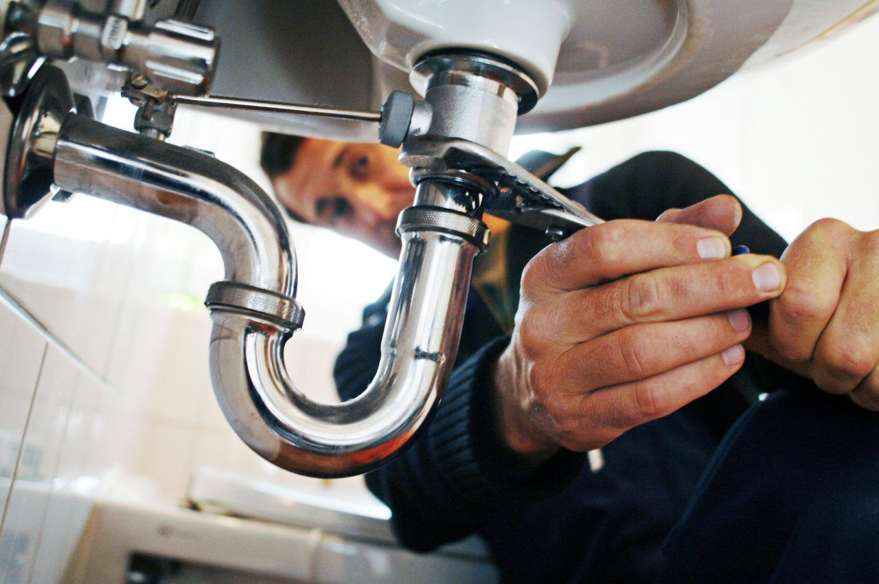 close-up-of-plumber-repairing-sink-with-tool-in-bathroom